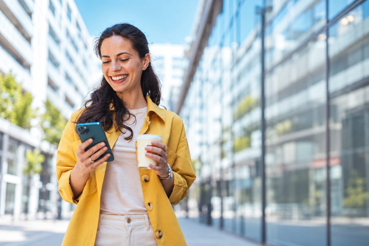 Woman in a yellow jacket using her phone in the city